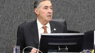 Ministro Luís Roberto Barroso em evento do STF, com legenda sobre sua alta hospitalar.