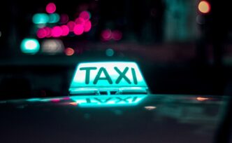 Taxistas em uma rua urbana, com a medida aprovada pela Câmara em destaque.