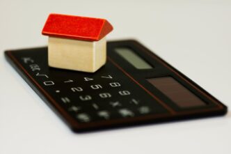 Representação de uma casa com símbolo de crédito imobiliário em destaque.