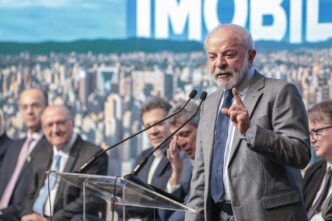 Presidente Lula discursando em evento sobre crédito imobiliário, com foco em sua fala sobre negociação com Trump.