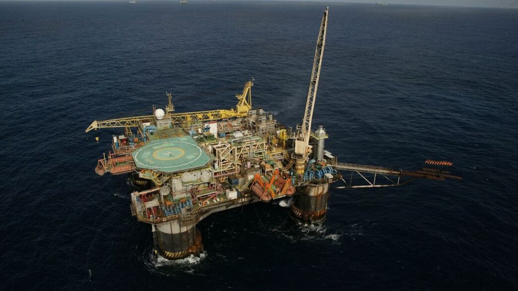 Plataforma de petróleo em exploração no pré-sal, refletindo a produção da commodity e o preço do petróleo.