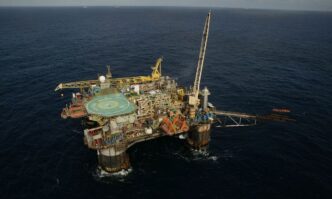 Plataforma de petróleo em exploração no pré-sal, refletindo a produção da commodity e o preço do petróleo.