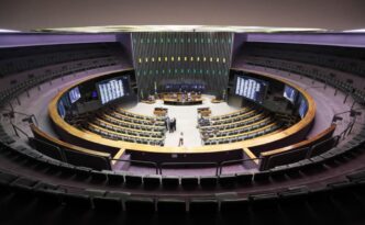 Plenário da Câmara dos Deputados em sessão, com parlamentares em discussões legislativas. A imagem está relacionada à votação da PEC da Previdência para agentes de saúde.