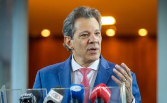 Ministro Fernando Haddad em evento, defendendo a queda da taxa de juros na véspera da reunião do Copom.