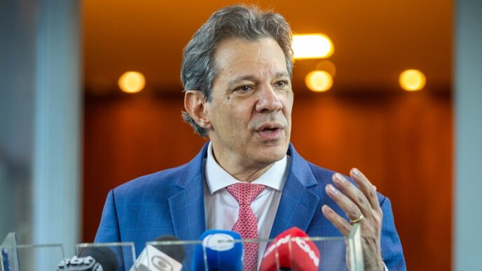 Ministro Fernando Haddad em evento, defendendo a queda da taxa de juros na véspera da reunião do Copom.