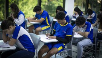 Estudantes recebendo materiais do programa Pé-de-Meia com foco na inclusão do Tesouro Direto.