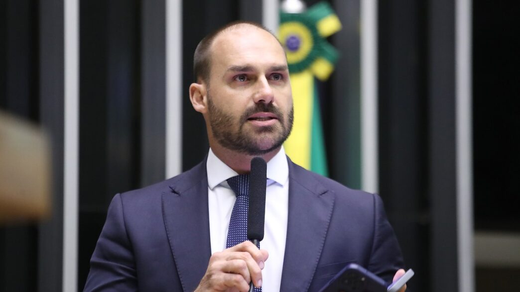 Deputado Eduardo Bolsonaro em evento na Câmara dos Deputados, contexto de seu julgamento no STF visando as eleições de 2026.