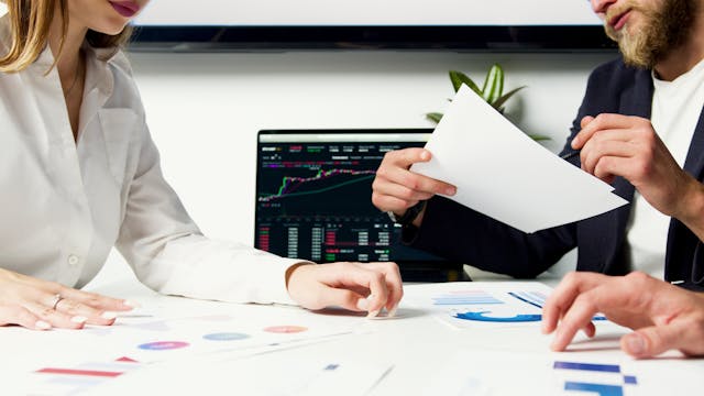 Profissionais do mercado financeiro em ambiente de escritório.