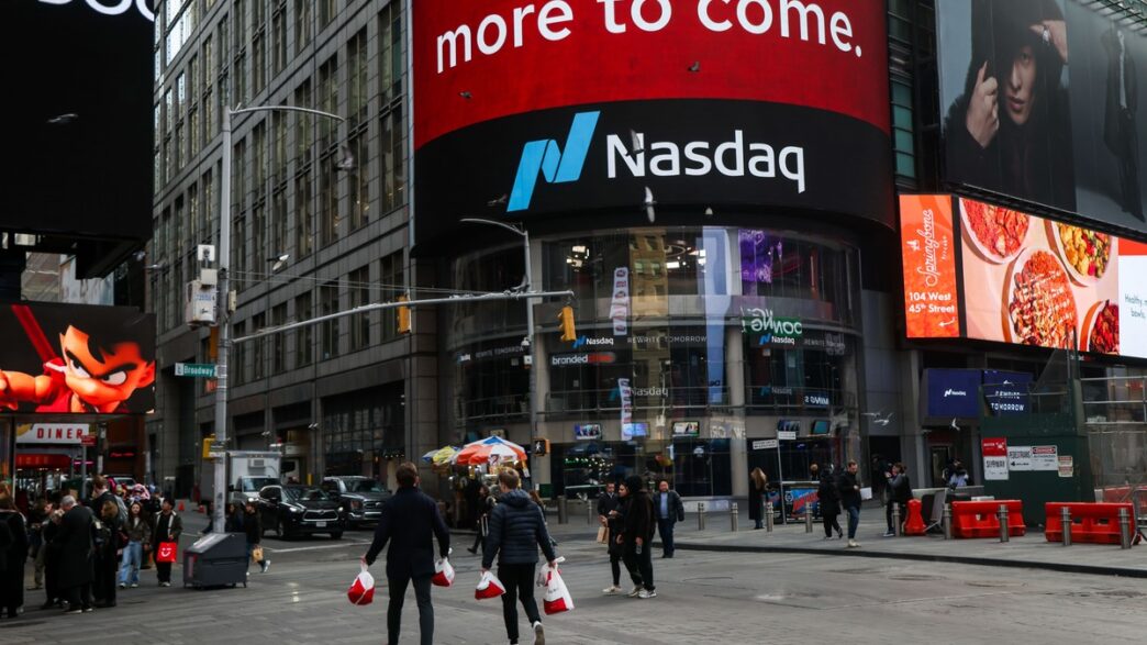 Painel eletrônico de negociações em Wall Street exibindo queda nos índices.