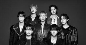 Membros do grupo BTS em apresentação, representando o modelo de negócio da Hybe.
