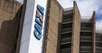 Fachada de agência da Caixa Econômica Federal em centro urbano.