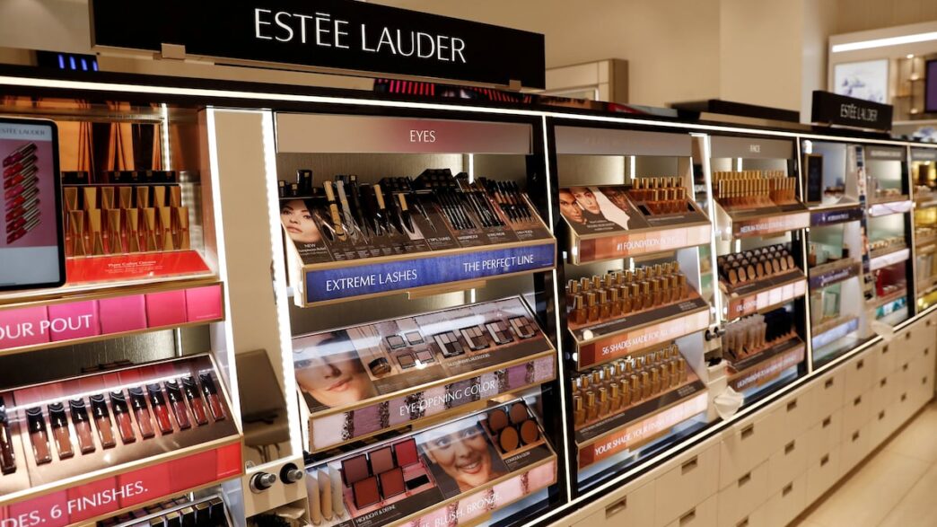 Logotipos da Estée Lauder e Puig representando a fusão das empresas.