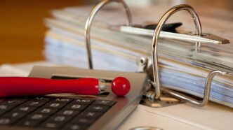 Documentos e formulários do Imposto de Renda sobre uma mesa de escritório.