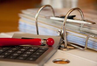 Documentos e formulários do Imposto de Renda sobre uma mesa de escritório.