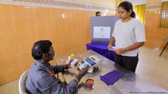 Eleitores indianos aguardam em fila para votar em seção eleitoral.