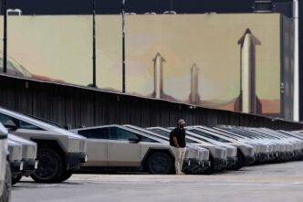 Logotipo da Tesla e representação de veículos elétricos em linha de montagem.